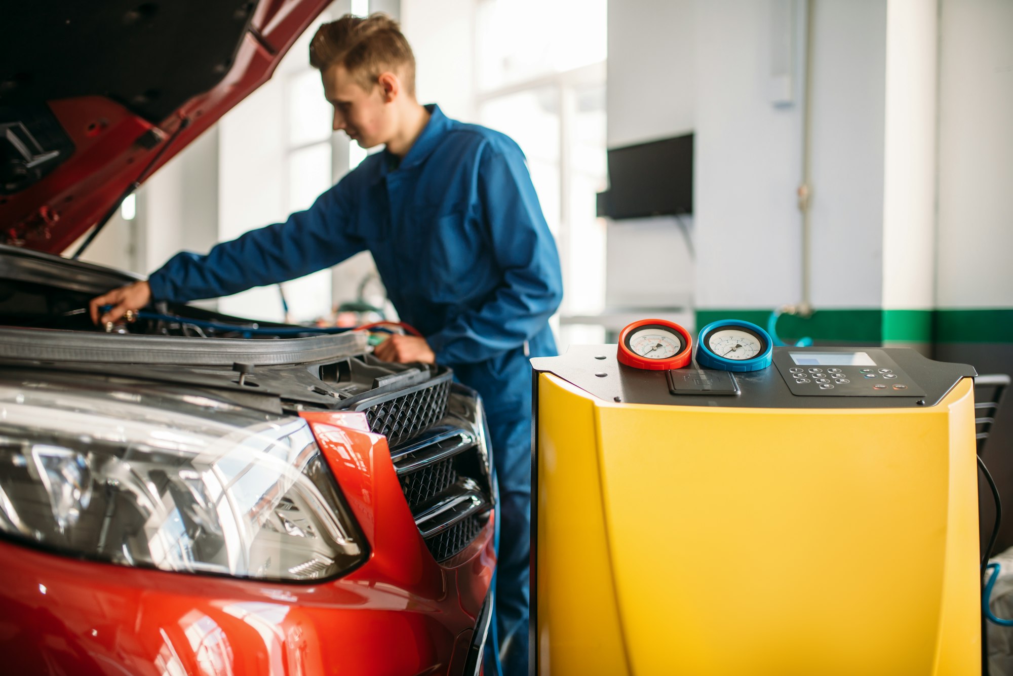 Mechanic checks air conditioning system in car